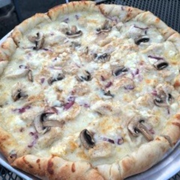 A white pizza from Tony M's with mushrooms, red onions, and a golden crust.