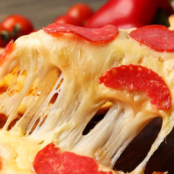 A slice of Tony M's pepperoni pizza with melted, stringy cheese being pulled away.