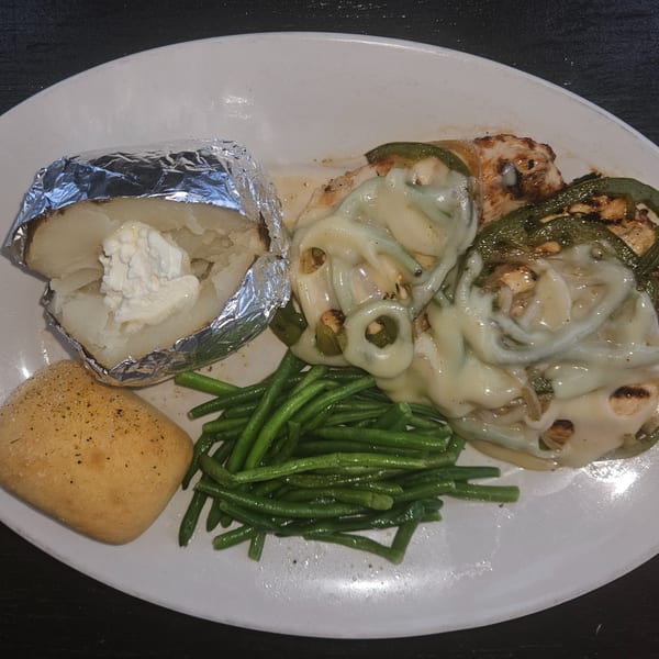 Tony M's Italian chicken with melted cheese, green beans, baked potato with sour cream, and a roll.