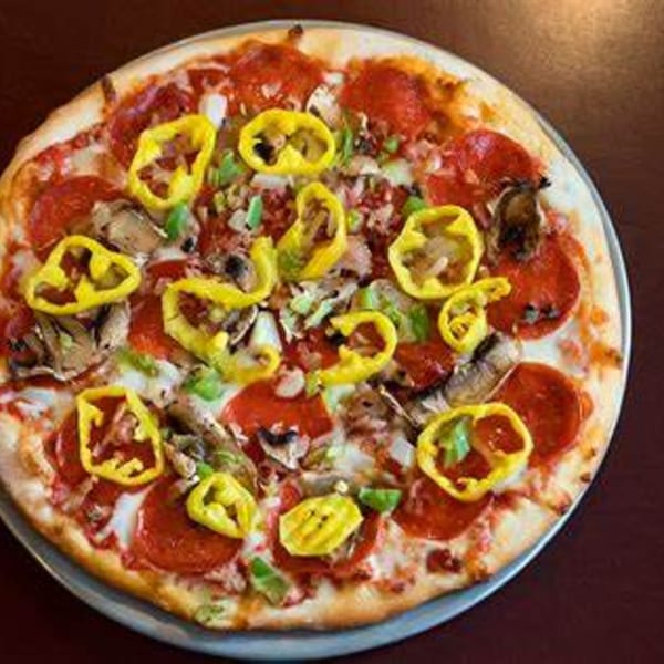 A whole Italian pizza from Tony M's, topped with pepperoni, mushrooms, green peppers, and banana peppers.