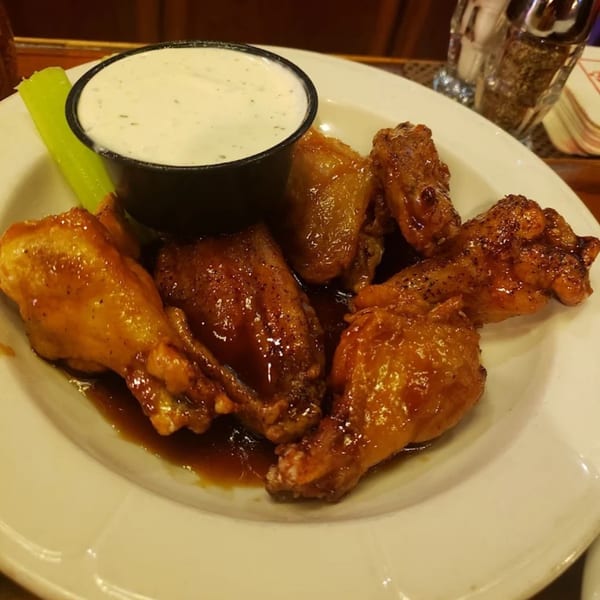 Tony M's Restaurant's Italian chicken wings with sauce and a side of ranch dressing and celery.