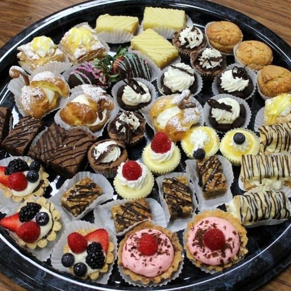 A large black tray filled with a variety of Italian pastries and desserts from Tony M's.