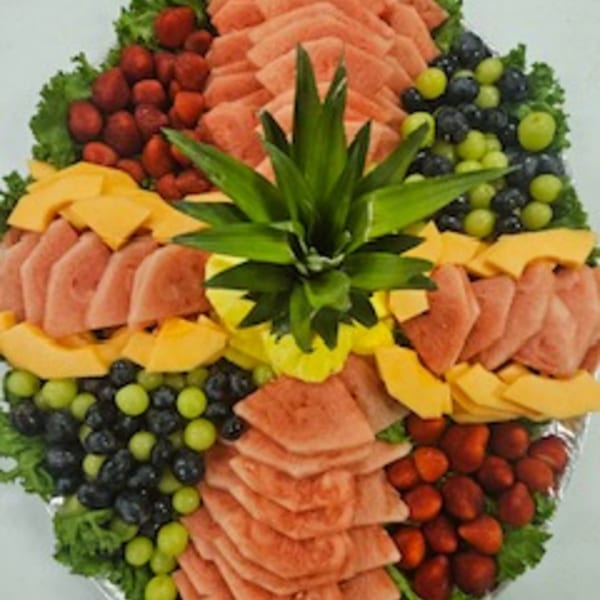 A large fruit platter with watermelon, cantaloupe, strawberries, blueberries, and green grapes.