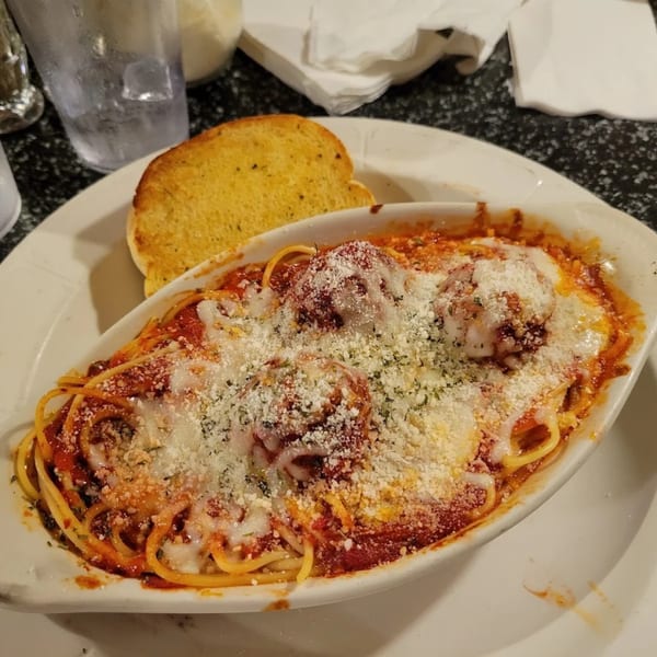 Baked spaghetti and meatballs with melted cheese and garlic bread at Tony M's.