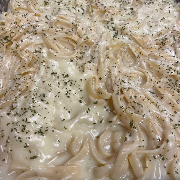Creamy fettuccine alfredo pasta with parsley flakes, a classic Italian dish from Tony M's.